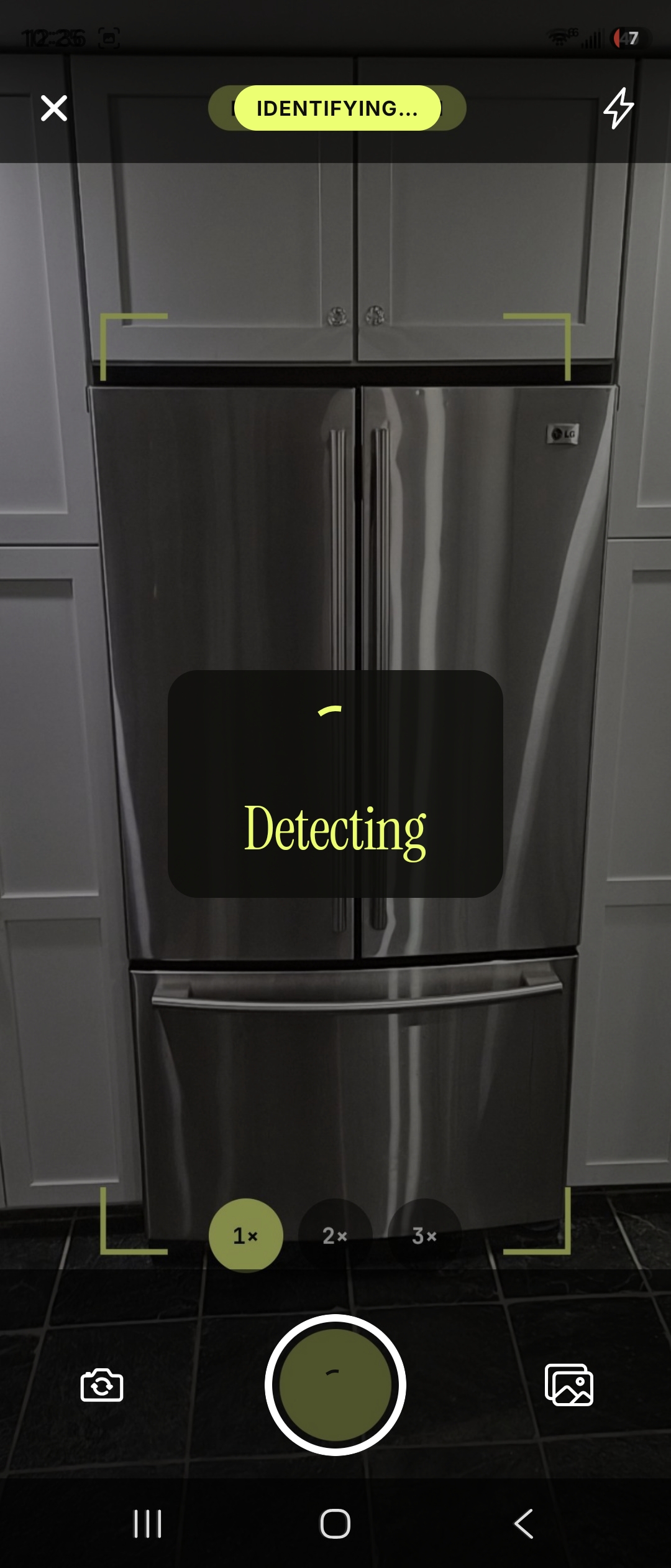 Scraplift camera screen aimed at a stainless steel French-door refrigerator with a framing reticle, an IDENTIFYING banner, zoom controls, and a shutter button.